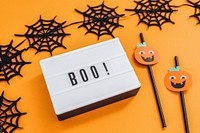 Boo on a white letter board surrounded by spider web garland 