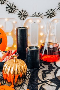 Halloween decoration with a pumpkin jar and a flask filled with red liquid 