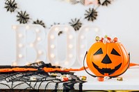 Halloween home decoration with a pumpkin basket filled with candies 