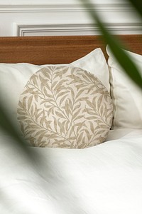 Interior designer placing a round cushion on a bed