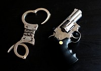Handcuffs and gun with black background