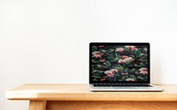 Laptop with flowers wallpaper on a wooden table