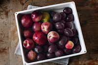 Fresh plums and apples on a plate