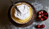 Chef spreading meringue to lemon tart