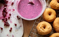 Fried donuts ready to be dipped in pink frosting