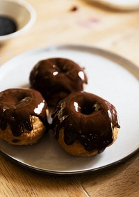 Chocolate glazed donuts on a plate