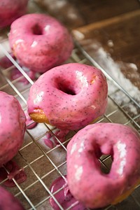 Pink glazed donuts on a cooling rack