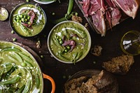 Bowls of green pea soup on a wooden table