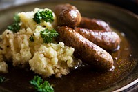 Bangers and mash on a brown plate
