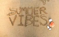 Summer vibes written in the sand