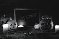 Halloween pumpkins and candles with blackboard