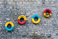 Colorful tires decorated on a stony wall