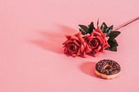 Tasty glazed donut beside a rose