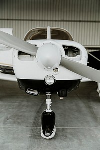 Front propellor plane parked in a hangar