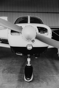 Front propellor plane parked in a hangar