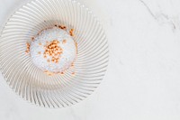 Donut decorated with sprinkles on a white table