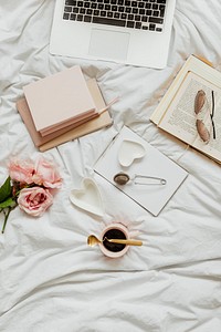 Laptop and notebooks on a girls bed