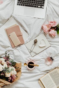 Laptop and notebooks on a girls bed