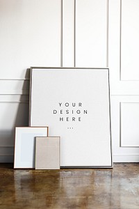 Blank frame mockup by a white wall