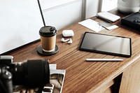 Digital tablet with an analog camera on a wooden table