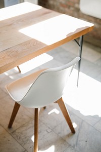 Wooden table and white chair on a marble floor