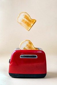 Roasted toast bread popping up from a red toaster