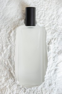 Blank perfume glass bottle on powder textured background