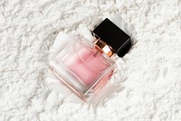 Feminine perfume glass bottle on powder textured background