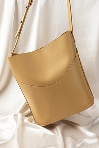 Beige shoulder bag mockup against a white sheet 