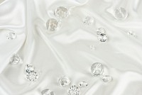 Decorative clear diamonds on white fabric textured background