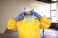 A healthcare worker donning a pair of protective goggles and protective equipment. Original image sourced from US Government department: Public Health Image Library, <a href="https://www.rawpixel.com/search/cdc?sort=curated&amp;page=1">Centers for Disease Control and Prevention</a>. Under US law this image is copyright free, please credit the government department whenever you can&rdquo;.