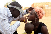 A diagnostic technician performing an eye exam. Original image sourced from US Government department: Public Health Image Library, Centers for Disease Control and Prevention. Under US law this image is copyright free, please credit the government department whenever you can”.