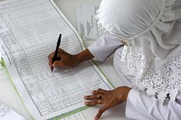 An Indonesian midwife entering birth data in a new log book at University Hospital, in Banda Ache, after the Sumatra tsunami of 2004.