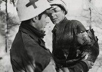 Medic giving first aid to soldier in Belgium, World War II. Original image from National Museum of Health and Medicine. Digitally enhanced by rawpixel.