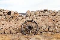 Wagon wheel against a stone fence at Hueco Tanks State Park, northwest of El Paso, USA. Original image from <a href="https://www.rawpixel.com/search/carol%20m.%20highsmith?sort=curated&amp;page=1">Carol M. Highsmith</a>&rsquo;s America, Library of Congress collection. Digitally enhanced by rawpixel.