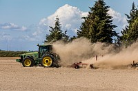 A farmer's tractor kicks up dust in a field, Washington. Original image from Carol M. Highsmith&rsquo;s America, Library of Congress collection. Digitally enhanced by rawpixel.