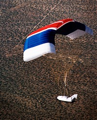 The X-38 Crew Return Vehicle descends under its steerable parafoil over the California desert in its first free flight at the Dryden Flight Research Center, Edwards, California. Original from NASA. Digitally enhanced by rawpixel.