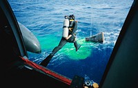 A Navy frogman leaps from a recovery helicopter into the water to assist in the Gemini-12 recovery operations. Original from NASA . Digitally enhanced by rawpixel.