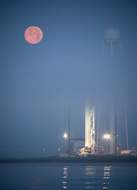 The full Moon sets in the fog behind the Orbital Sciences Corporation Antares rocket. Original from NASA. Digitally enhanced by rawpixel.