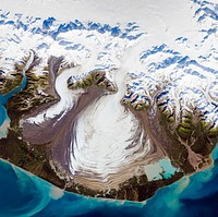 The ice of a piedmont glacier spills from a steep valley onto a relatively flat plain. Malaspina Glacier, Alaska. Original from NASA. Digitally enhanced by rawpixel.