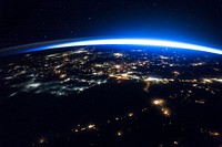 Night image of sparkling cities and a sliver of daylight framing the northern hemisphere. Original from NASA. Digitally enhanced by rawpixel.