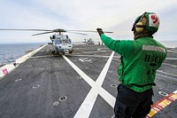SAN DIEGO, Calif. &ndash; A member of the Helicopter Sea Combat Squadron 8 signals to the pilot in an H60-S Seahawk helicopter on the deck of the USS Anchorage as the ship departs Naval Base San Diego in California for the open waters of the Pacific Ocean.<br />Dec 1st, 2014. Original from NASA. Digitally enhanced by rawpixel.