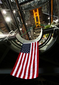 The American flag can be seen hanging from the final work platform, A north, as the platform is lifted up by crane from the transfer aisle in the Vehicle Assembly Building (VAB) at NASA&#39;s Kennedy Space Center in Florida. Original from NASA. Digitally enhanced by rawpixel.