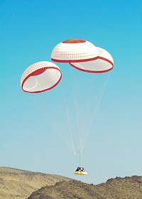 The Boeing Company's CST-100 crew capsule floats to a smooth landing beneath three main parachutes over the Delamar Dry Lake Bed near Alamo, Nevada. Original from NASA . Digitally enhanced by rawpixel.