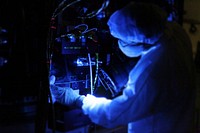 Using a black light, a technician closely inspects one of NASA's twin Radiation Belt Storm Probes inside the clean room high bay at Astrotech payload processing facility. Original from NASA. Digitally enhanced by rawpixel.