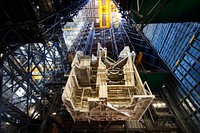 A large space shuttle-era work platform is being lowered and removed from high bay 3 of the Vehicle Assembly Building. Original from NASA . Digitally enhanced by rawpixel.