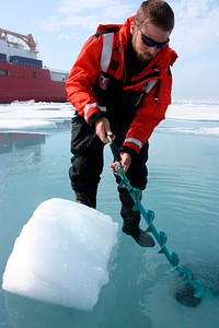 Dartmouth College&#39;s Chris Polashenski cuts a block of ice from below a melt pond on sea ice in the Chukchi Sea on July 9, 2010, for analysis upon return from the mission. Original from NASA. Digitally enhanced by rawpixel.
