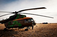 Russian Search and Rescue helicopter and crew await the arrival of an all-terrain vehicle. Original from NASA. Digitally enhanced by rawpixel.