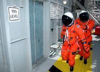 STS-115 Mission Specialists Heidemarie Stefanyshyn-Piper (front) and Daniel Burbank head for the slidewire baskets on Launch Pad 39B, practicing emergency egress procedures. Aug 10th, 2006. Original from NASA. Digitally enhanced by rawpixel.