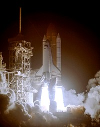 Space shuttle Discover standing on the fiery columns erupting from the solid rocket boosters as it lifts off Launch Pad 39B on mission STS-116. Original from NASA. Digitally enhanced by rawpixel.